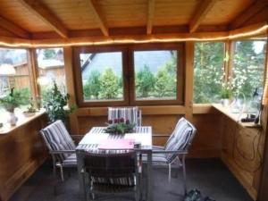 a dining room with a table and chairs and windows at Holiday Home Eifelwaldhäuschen by Interhome in Blankenheim