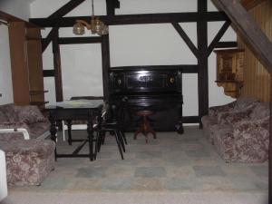 a living room with a piano and a table at Apartment Ausgebaute Scheune by Interhome in Kollnburg