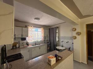 a kitchen with white cabinets and a counter top at NayaLoft in Naivasha