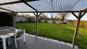 a patio with a table and chairs under a pergola at Chez Philomene in Surques