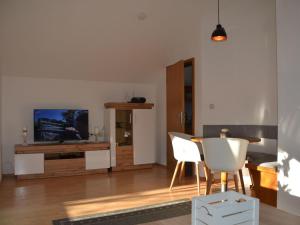 a living room with a television and a table and chairs at Apartment in Berghäuser by Interhome in Grafenwiesen