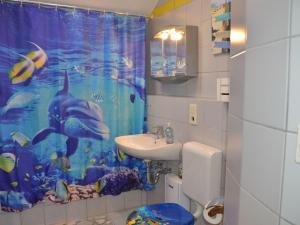 a bathroom with a dolphin shower curtain and a sink at Apartment in Berghäuser by Interhome in Grafenwiesen