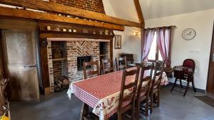 a dining room with a table and a fireplace at Chez Philomene in Surques
