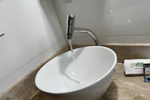 a white sink in a bathroom with a faucet at Casa Simples e Funcional em Araxá in Araxá +26 photos