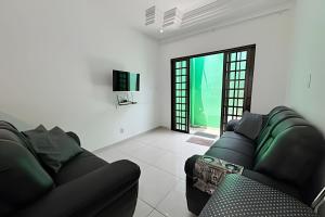 a living room with a couch and a tv at Casa Simples e Funcional em Araxá in Araxá