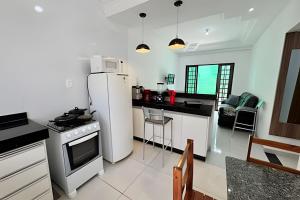 a kitchen with a white refrigerator and a stove at Casa Simples e Funcional em Araxá in Araxá