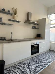 a kitchen with white cabinets and a sink at Luik city center in Liège