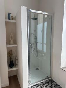 a shower with a glass door in a bathroom at Luik city center in Liège