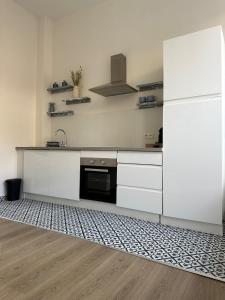 a kitchen with white cabinets and a refrigerator at Luik city center in Liège