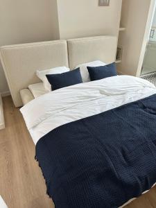 a large bed with blue and white sheets and a couch at Luik city center in Liège