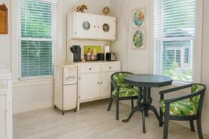 a kitchen with a table and a table and chairs at Gingerbird Art Suite in Laurel
