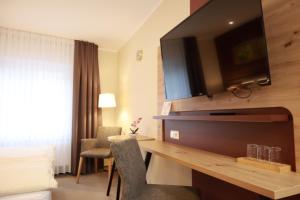a hotel room with a desk with a television on the wall at Weinhaus Gräfen in Cochem