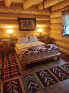 a bedroom with a bed in a log cabin at Rustic House in Predeal