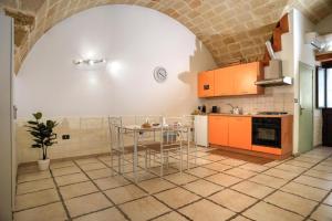 a kitchen with orange cabinets and a table at History Station in Brindisi +11 photos