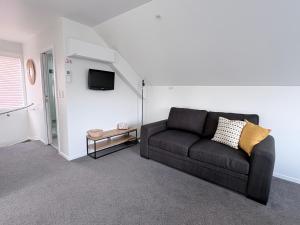 a living room with a couch and a tv at STUDIO42 in Papakura
