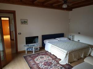 a bedroom with a bed and a flat screen tv at Corte Pomponazza in Mantova