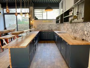 a kitchen with blue cabinets and a wooden counter top at La Sorga - gîte 12 personnes in Blesle