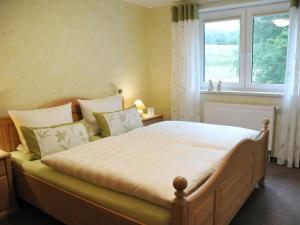 a bedroom with a large bed with a window at Apartment Wiesengrund by Interhome in Neuhaus am Rennweg