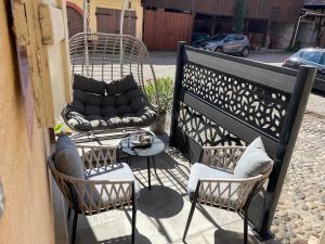 a patio with two chairs and a couch on a balcony at Studio 3 étoiles avec grand JACUZZI PRIVÉ in Horbourg