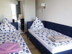 a room with two beds with blue and white pillows at Apartment Wünnowblick by Interhome in Röbel