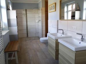 a bathroom with two sinks and a toilet at Apartment Wünnowblick by Interhome in Röbel +31 photos