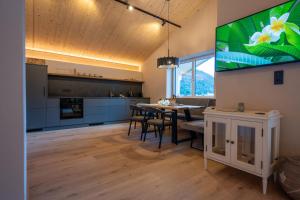 a kitchen and dining room with a large tv on the wall at Bomwäldele 89 in Bichlbach