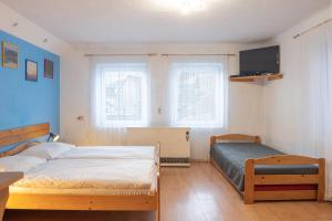 a bedroom with two beds and a tv on the wall at Apartment Jursport in Závažná Poruba