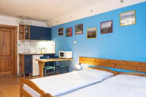 a bedroom with two beds and a blue wall at Apartment Jursport in Závažná Poruba