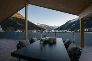 a table on a balcony with a view of mountains at Bomwäldele 89 in Bichlbach