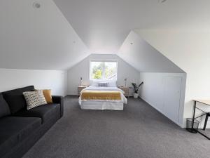a white bedroom with a bed and a window at STUDIO42 in Papakura