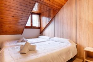 a large white bed in a room with wooden walls at Hotel Hipic in Vielha +70 photos