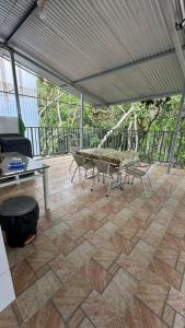 a patio with a table and chairs on a patio at Hospedagem da Bela Quarto 7 Banheiro compartilhado in Caparaó Velho