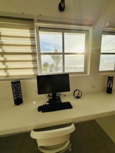 a computer sitting on a desk in front of a window at Bed and Cactus - Ocean View Villa in El Sargento