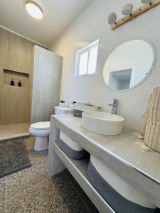 a bathroom with a sink and a toilet and a mirror at Bed and Cactus - Ocean View Villa in El Sargento +14 photos