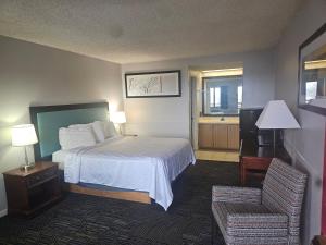 a hotel room with a bed and a chair at Hawk's Nest Lodge in Osage Beach +10 photos