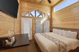a bedroom with a large bed in a wooden room at Page Lake Powell Campground - Tiny Home King Room in Page +3 photos