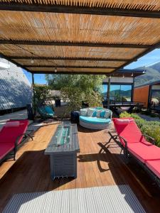a patio with a wooden deck with chairs and a table at TEMEXKAL RESORT in Ensenada