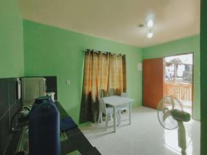 a room with green walls and a table and a window at Charming Urban Hideout in Puerto Princesa City