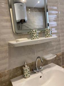 a bathroom with a sink and a mirror at loved modern home 2BR in New cairo +18 photos