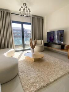 a living room with a couch and a tv at loved modern home 2BR in New cairo