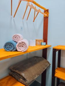 a wooden shelf with towels and towels at Chalés Refúgio da Sil in Cavalcante