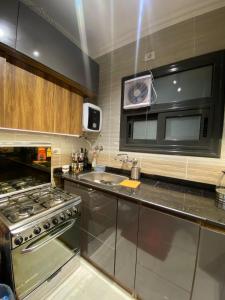 a kitchen with a stove and a microwave at loved modern home 2BR in New cairo