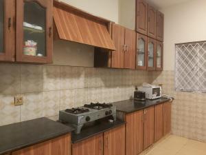 a kitchen with wooden cabinets and a stove at Dove INN Express II in Lahore