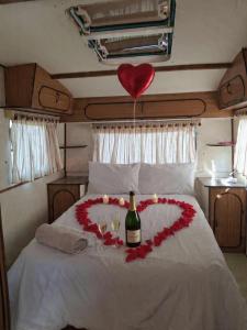 a heart shaped bed with a bottle of wine and a balloon at DSC Family Fun Park in Standerton