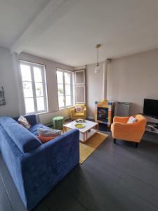 a living room with a blue couch and two chairs at Maisonnette à Saint Valéry Sur Somme in Saint-Valéry-sur-Somme