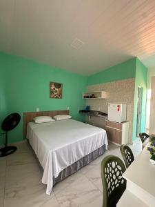a bedroom with a white bed and green walls at Mar e Sol Tabatinga in Nísia Floresta