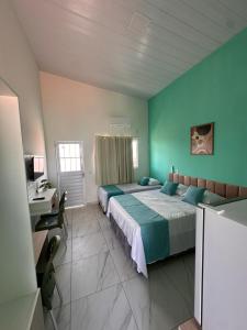 a large room with two beds and a desk and a bed sidx sidx sidx sidx at Mar e Sol Tabatinga in Nísia Floresta