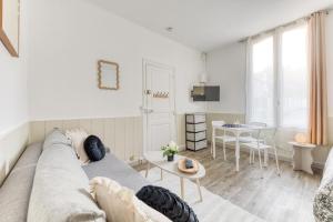 a living room with a couch and a table at Le Signature Studio in Dreux