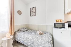 a small bedroom with a bed and a microwave at Le Signature Studio in Dreux