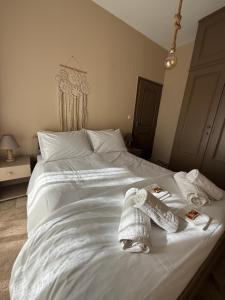 a white bed with towels on top of it at Sea&Nature apartment in Aigio